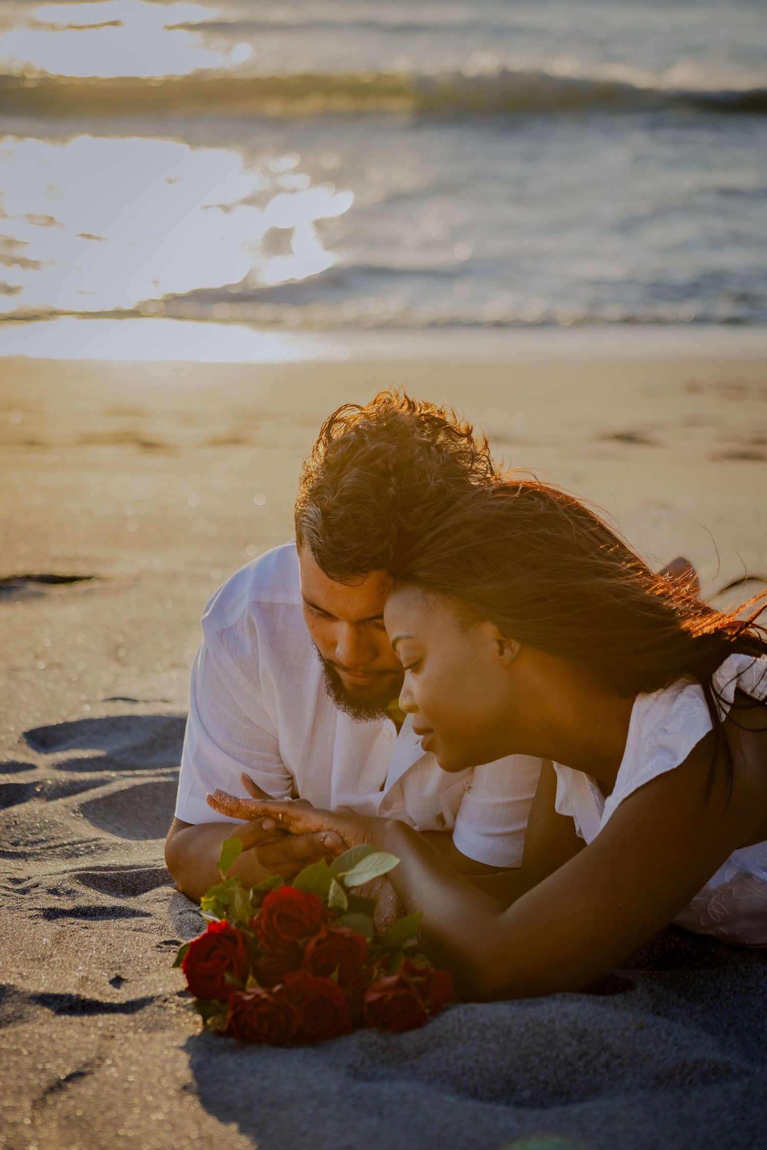 Couple resting on the beach with roses