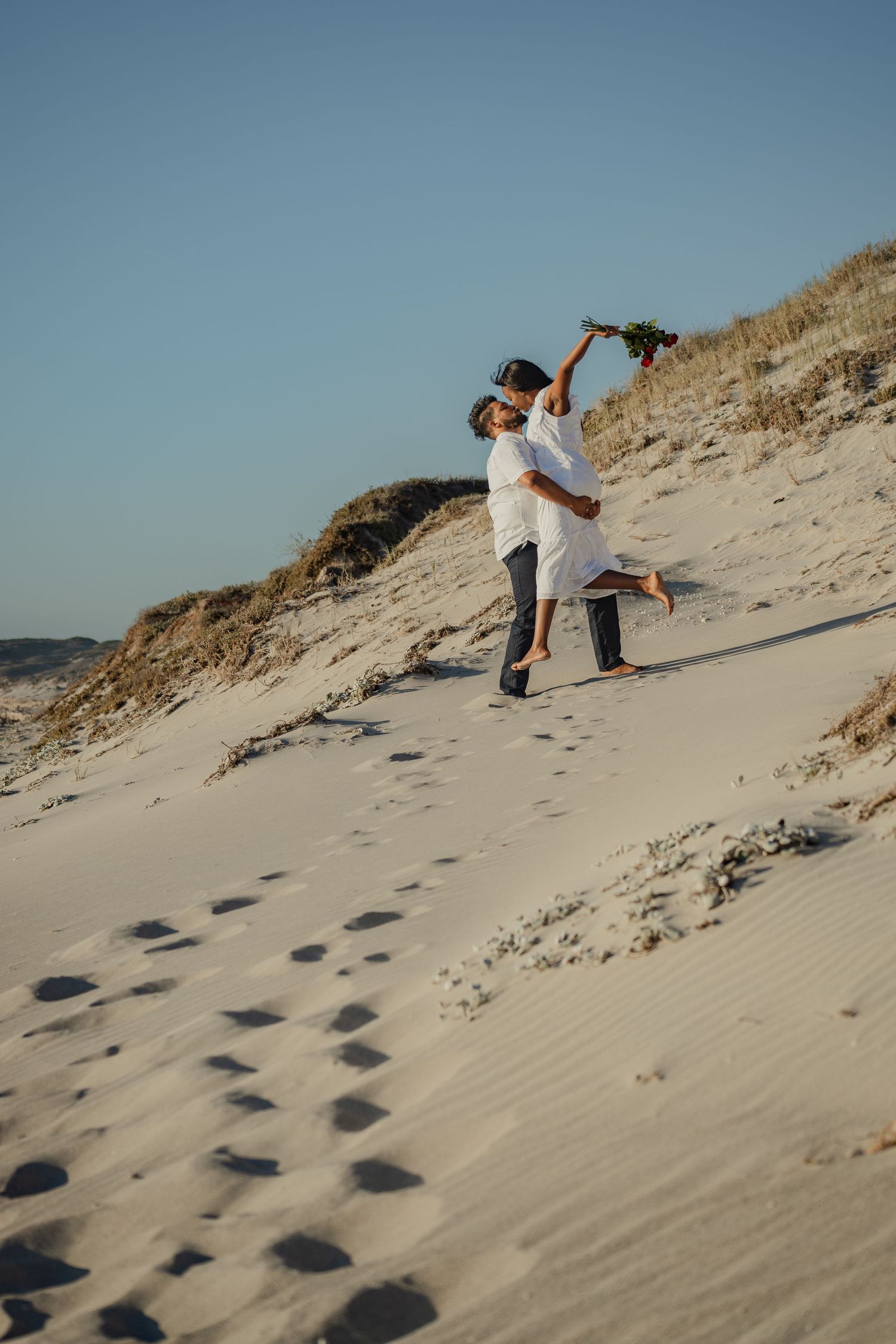Couple dancing together on the sand dune