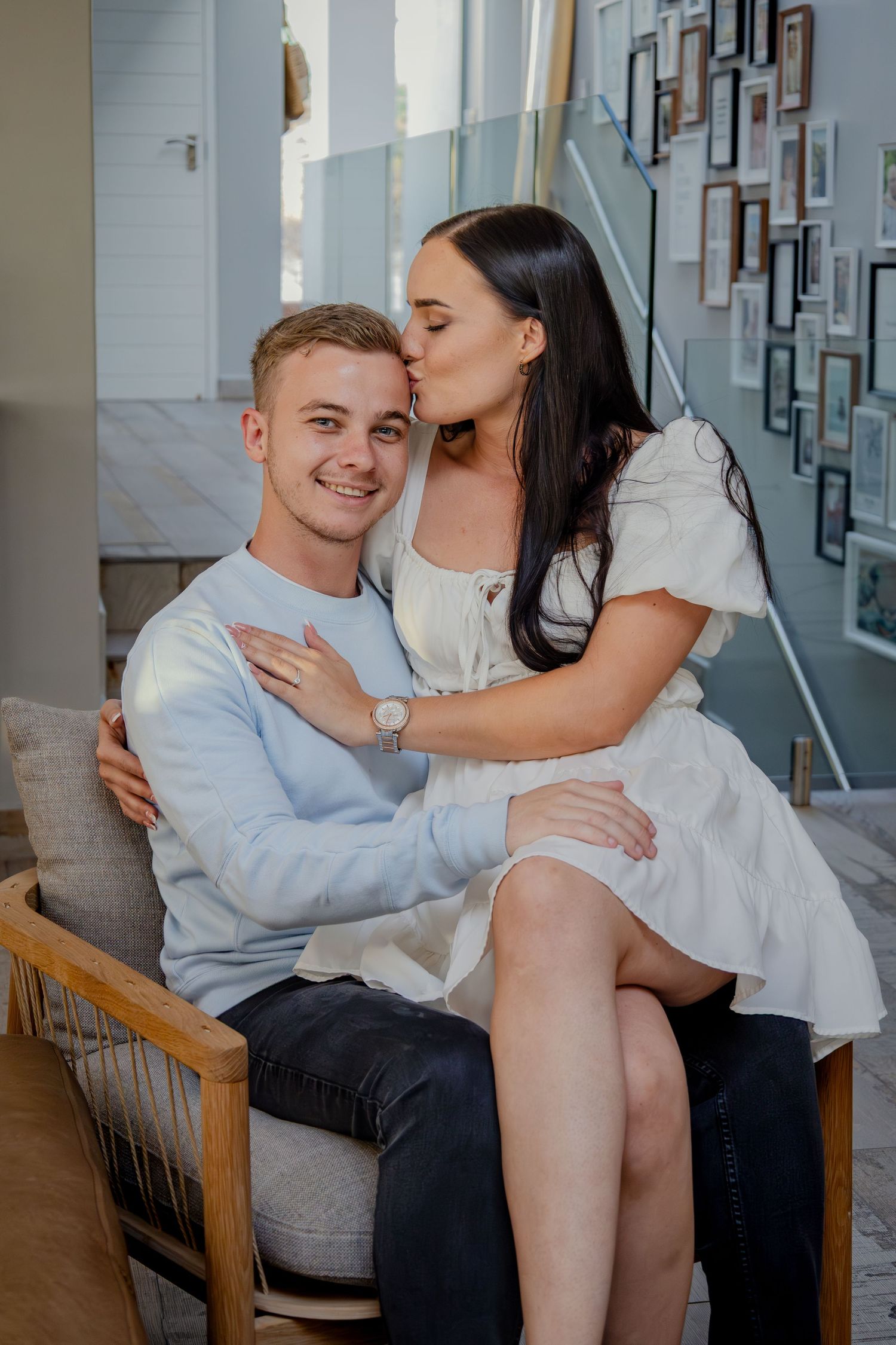 Couple cuddling indoors on a chair
