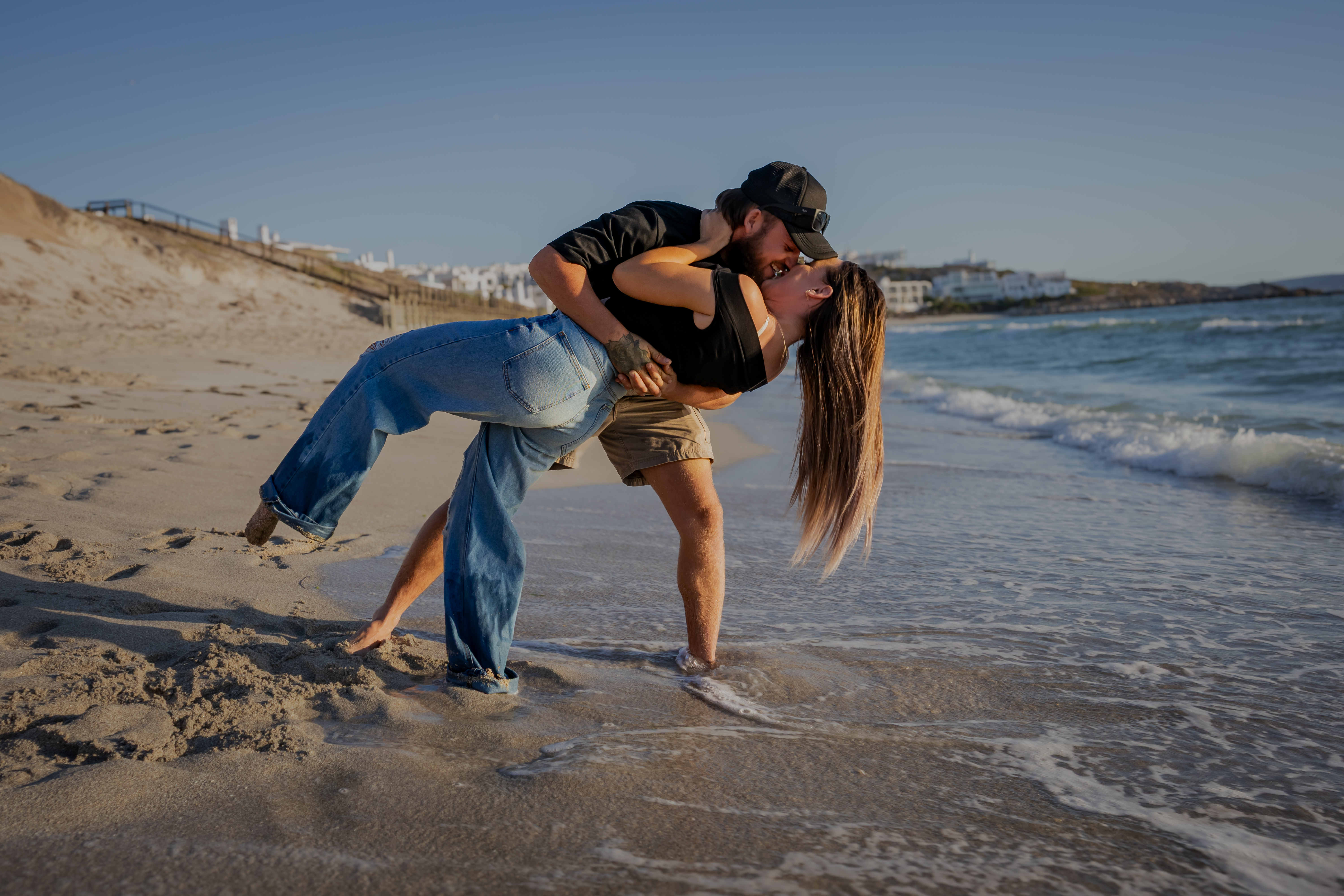 Couple dip kiss on the shoreline