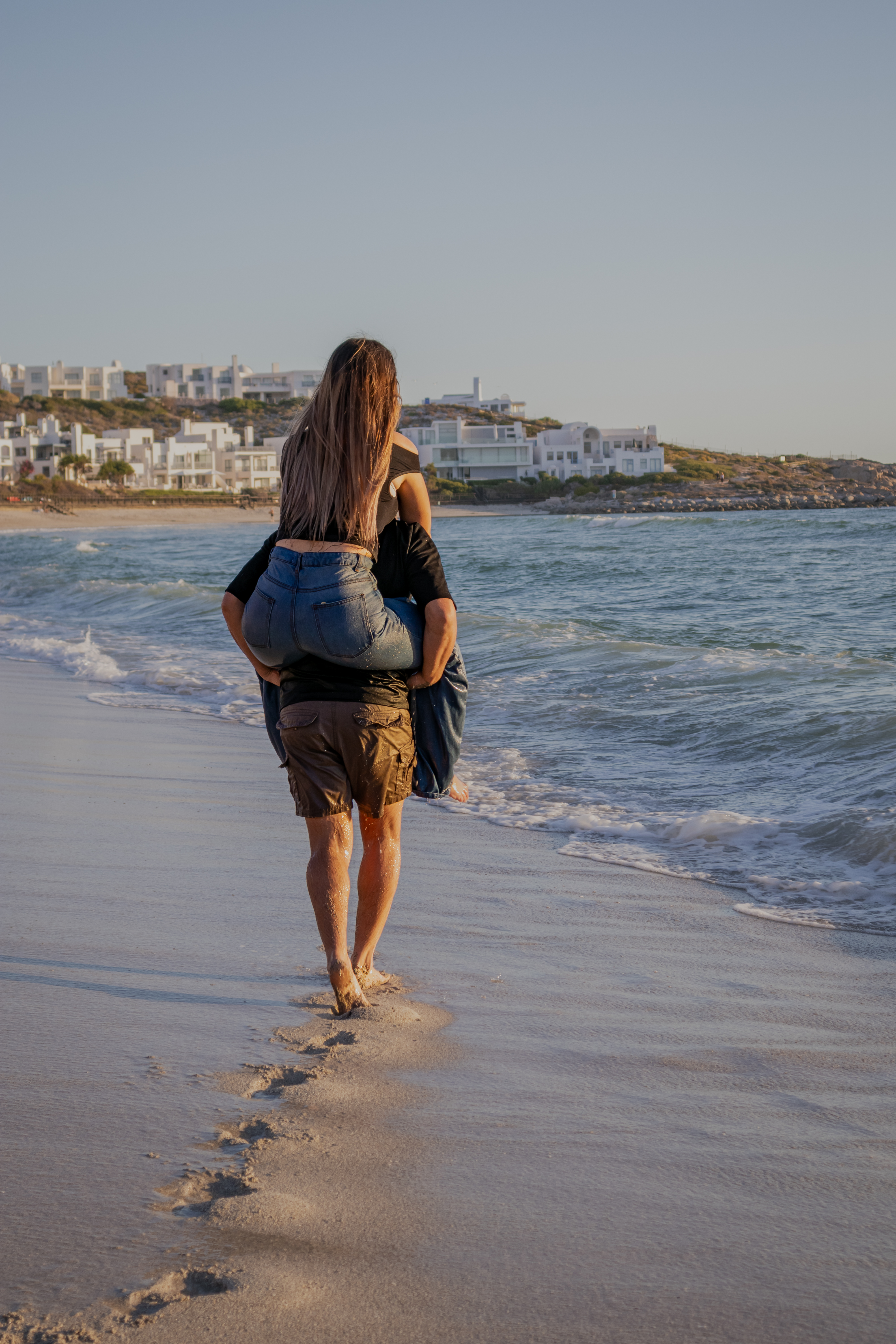 Couple walking away along the shoreline