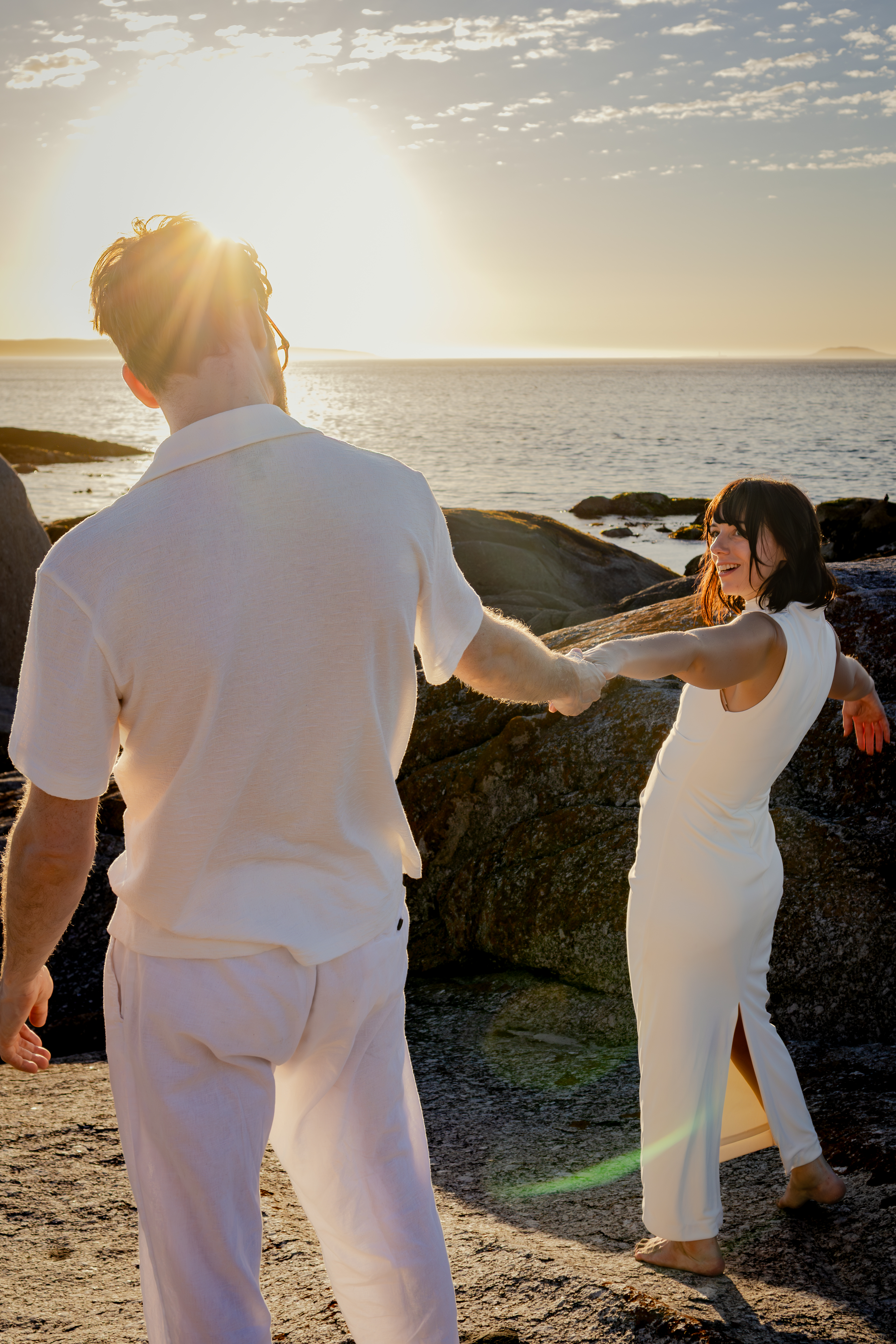 Bride standing in the surf during sunset