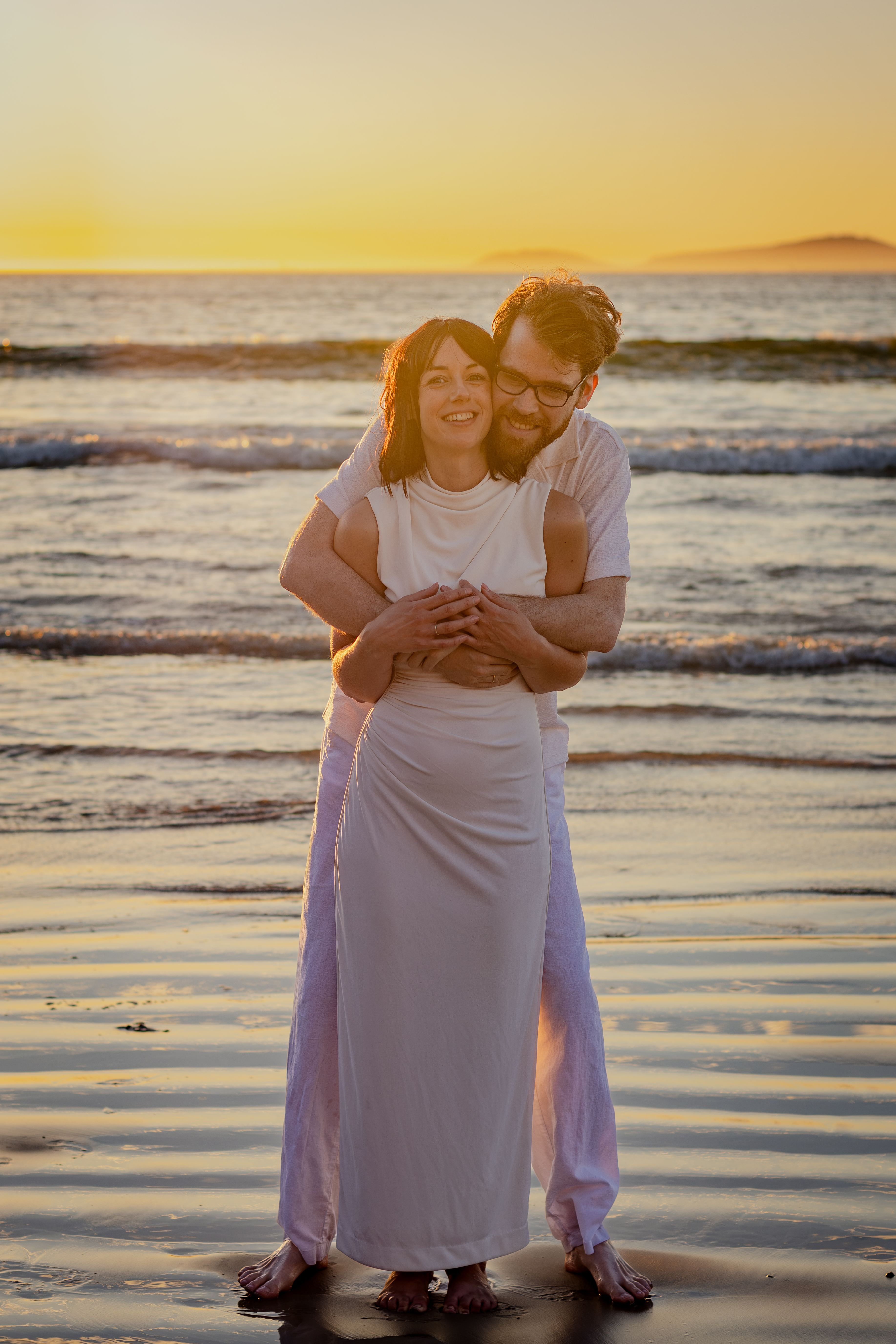 Bride standing with folded arms in sunset light