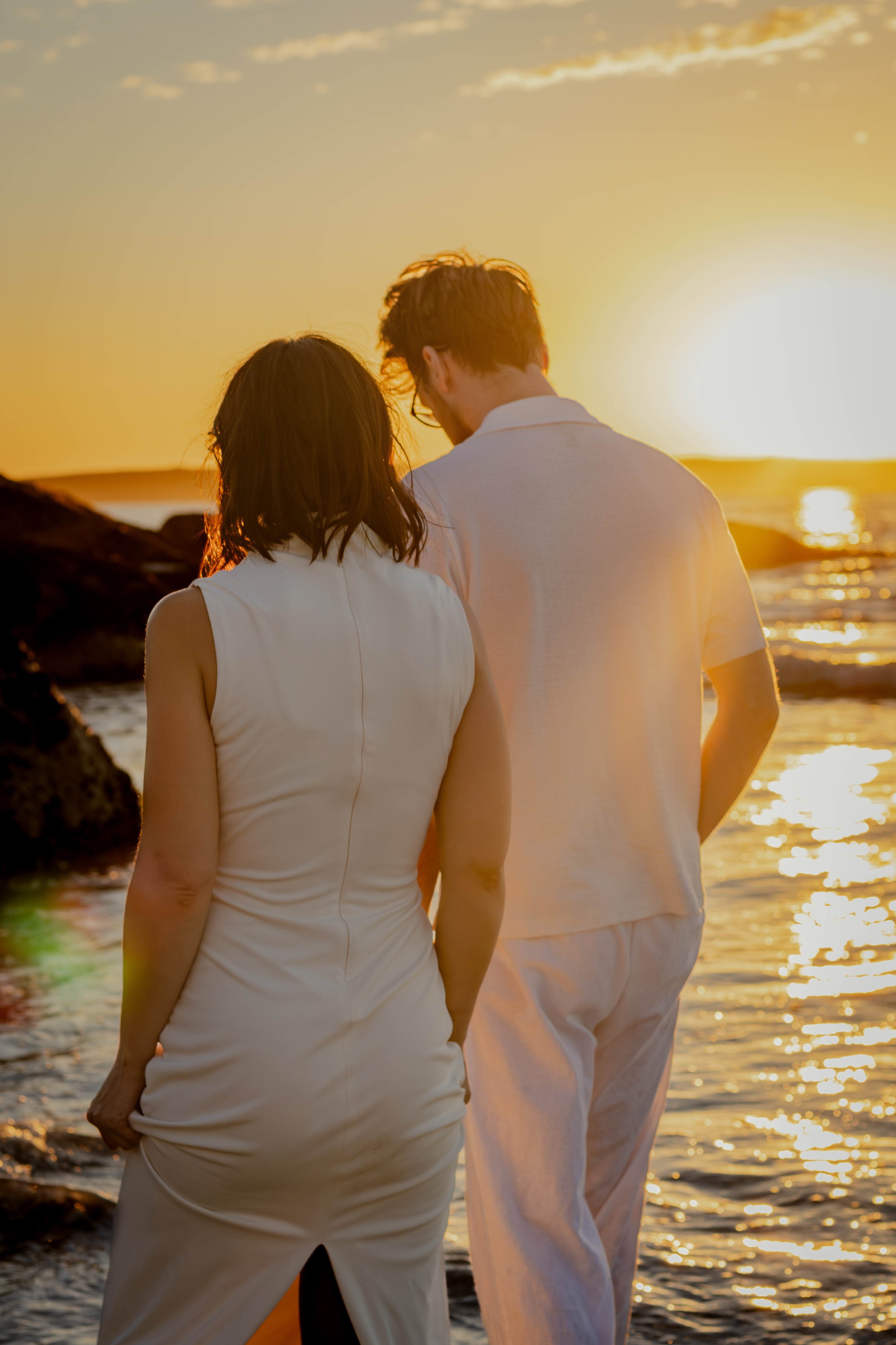 Couple holding one another by the shoreline