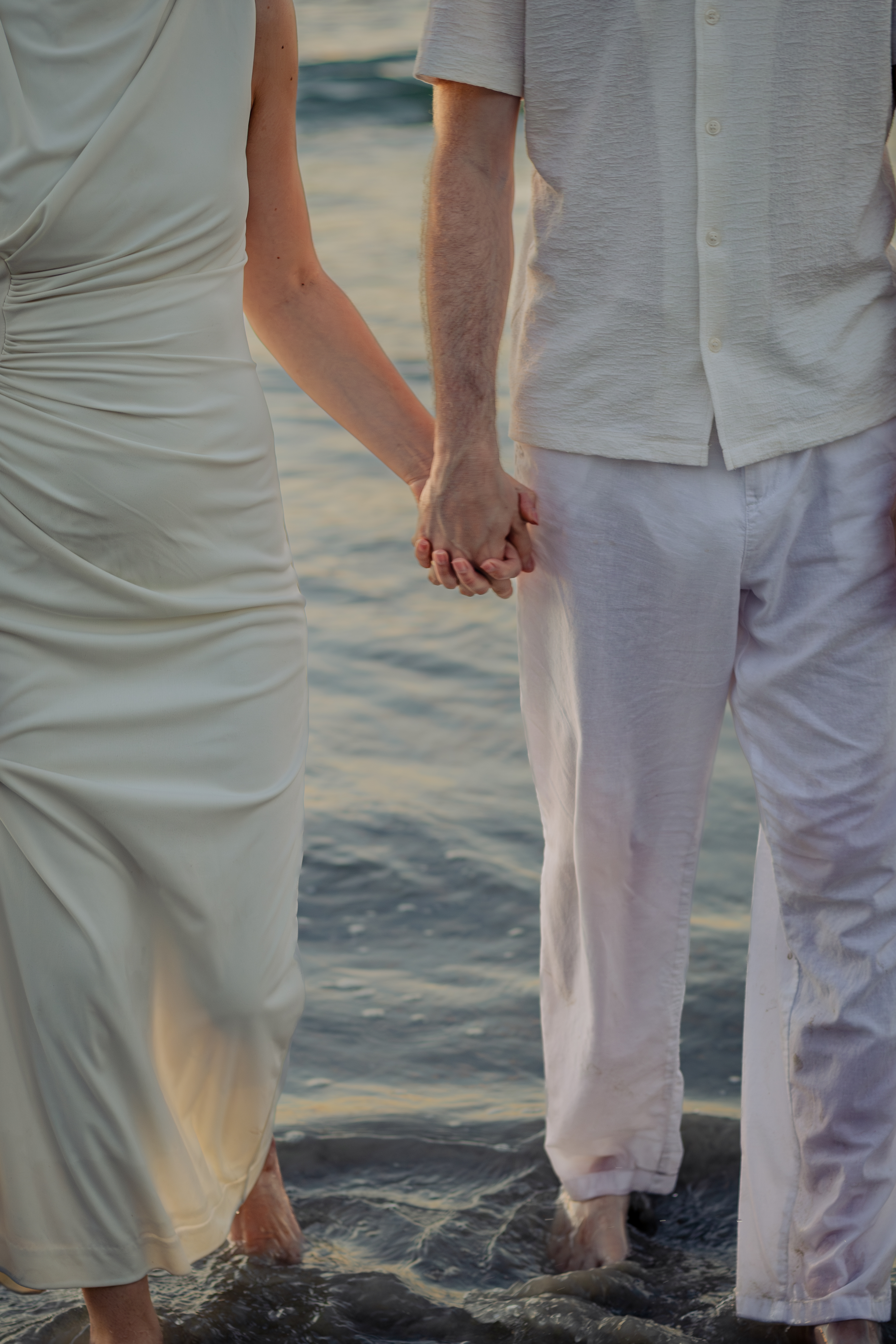 Close-up of a couple holding hands on the beach