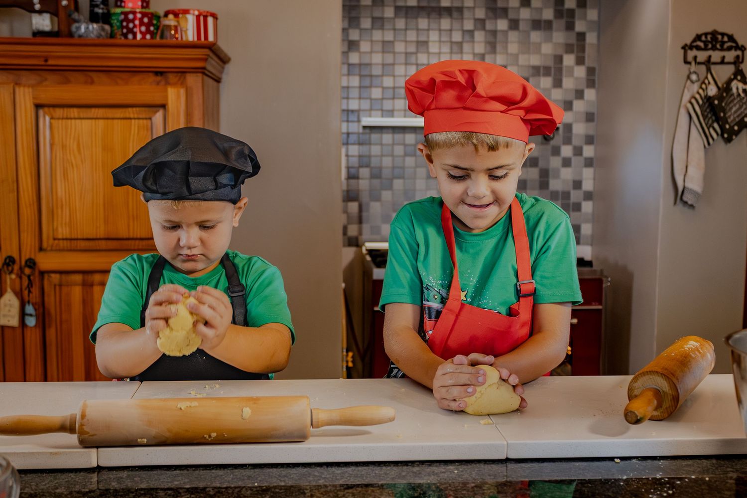 Children in aprons preparing dough in the kitchen