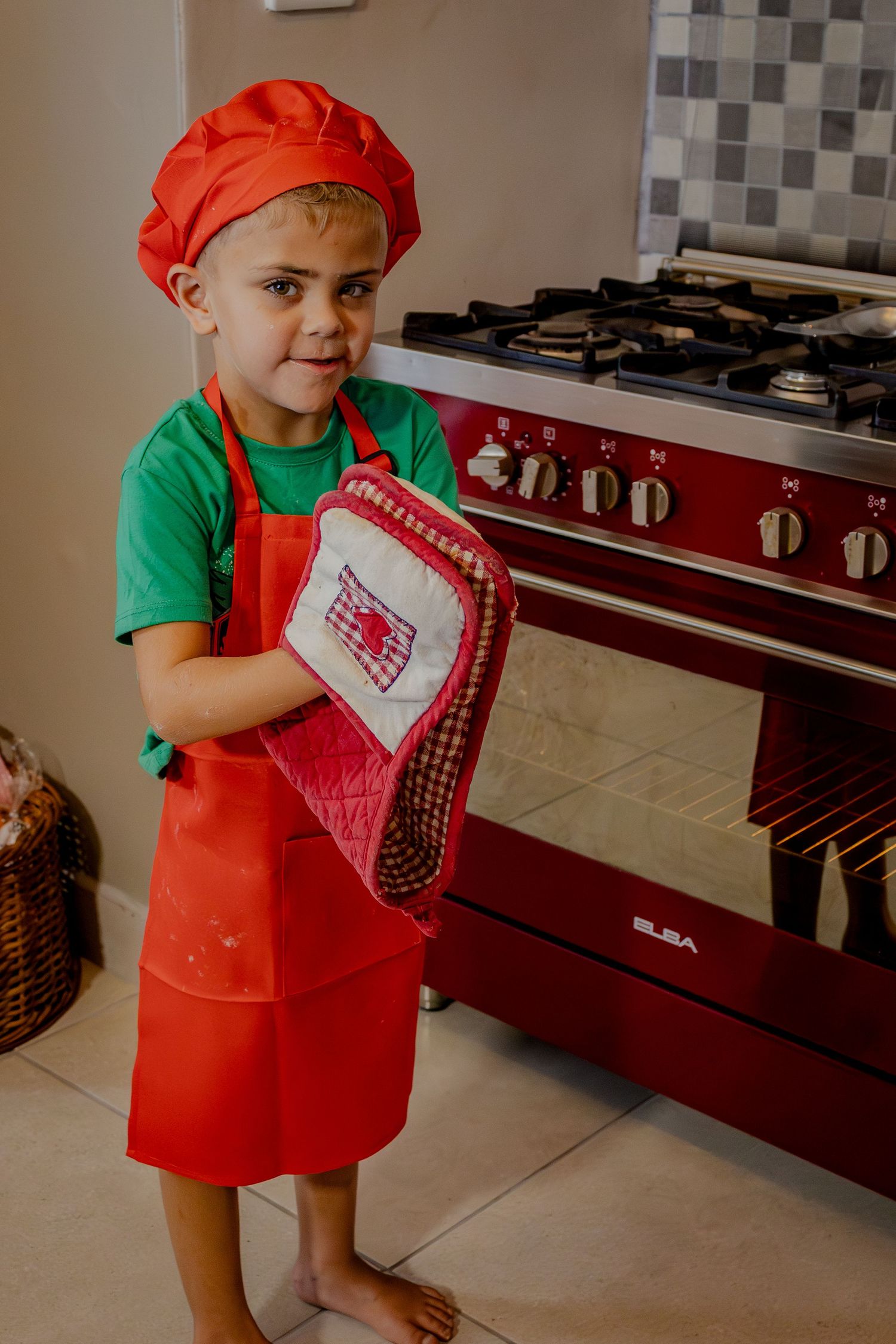Child holding a recipe book in a kitchen portrait
